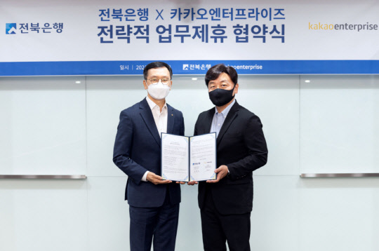 백상엽 카카오엔터프라이즈 대표(오른쪽)와 서한국 전북은행 은행장이 지난 28일 JB금융그룹 여의도 사옥에서 업무협약을 체결한 뒤 기념사진을 찍고 있다. 카카오 제공